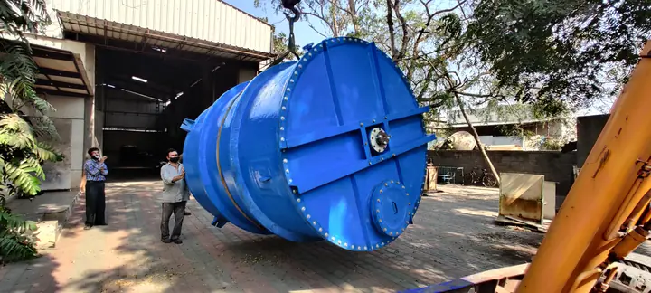 A blue process vessel outside the Plasto-Fab works