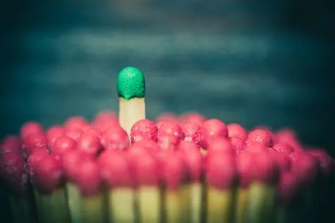 One green match standing out among red ones