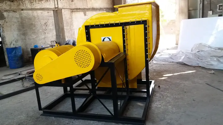 A yellow centrifugal blower on a steel frame